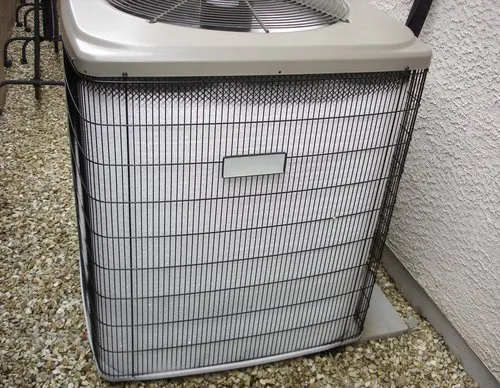 Ice and frost on the coil of an outdoor heat pump in winter, a common reason homeowners ask about heat pump emergency heat